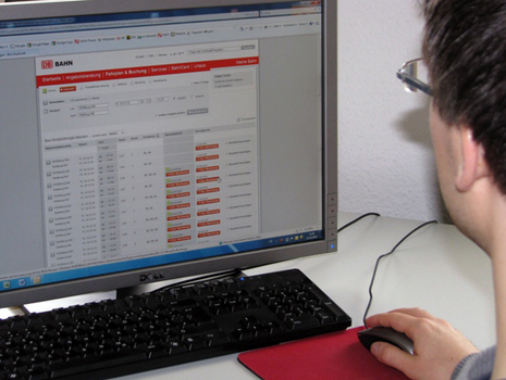"Mann vor Monitor mit Online-Fahrkarten-Service der Deutschen Bahn