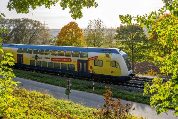 BIld eines blau-gelben Doppelstockwagens im Herbst